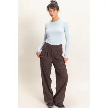 woman wearing light blue top and brown pants