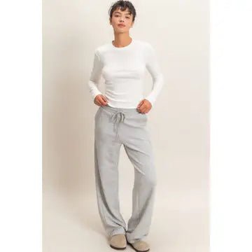 Woman wearing white long sleeve to and gray jogging pants