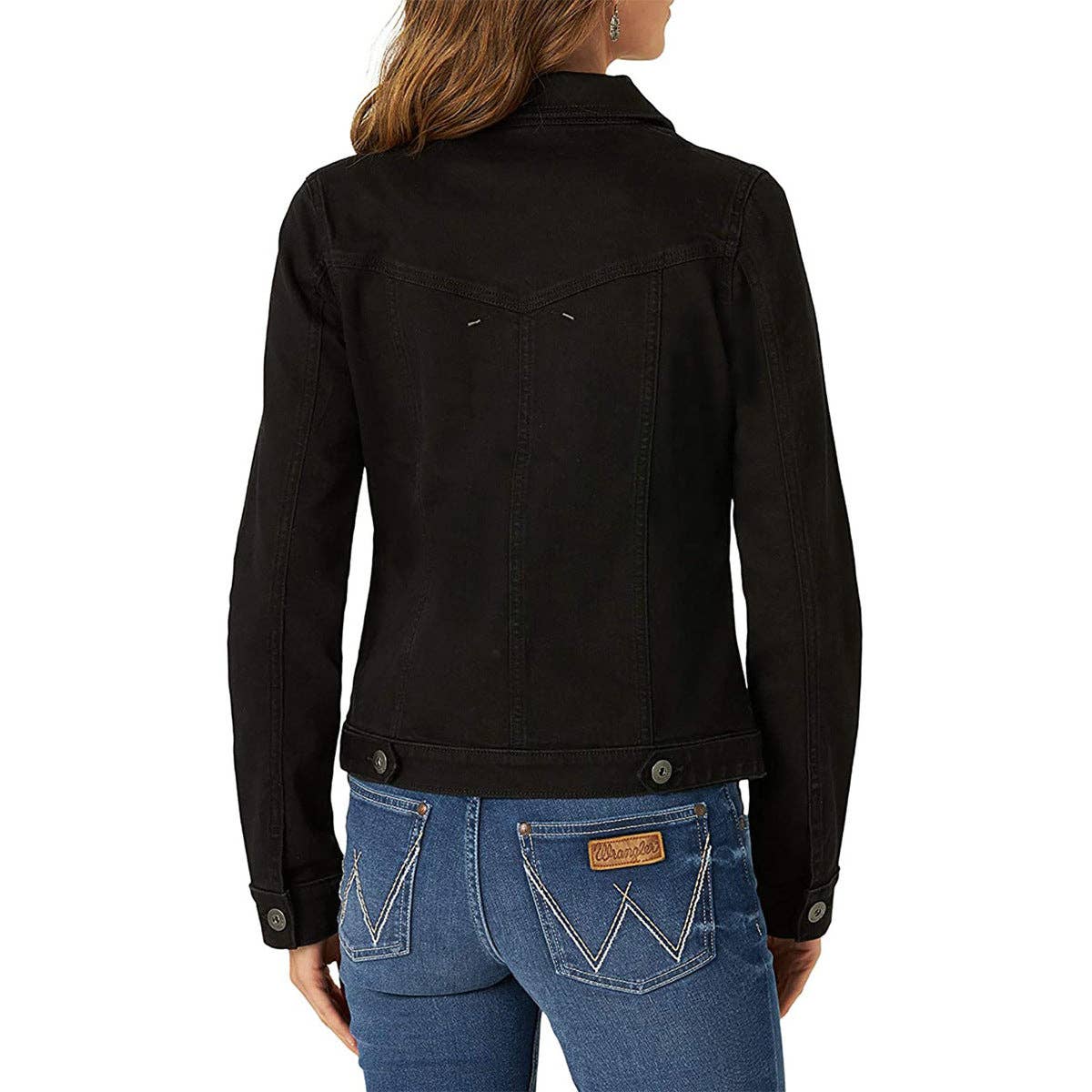 A woman shown from the back wearing a black denim jacket and blue jeans with distinctive white contrast stitching on the back pockets.