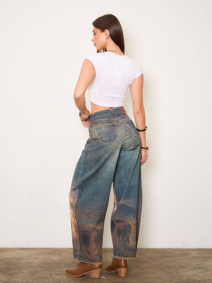 Woman wearing a white crop top and blue jeans with a nature print, standing against a plain background.