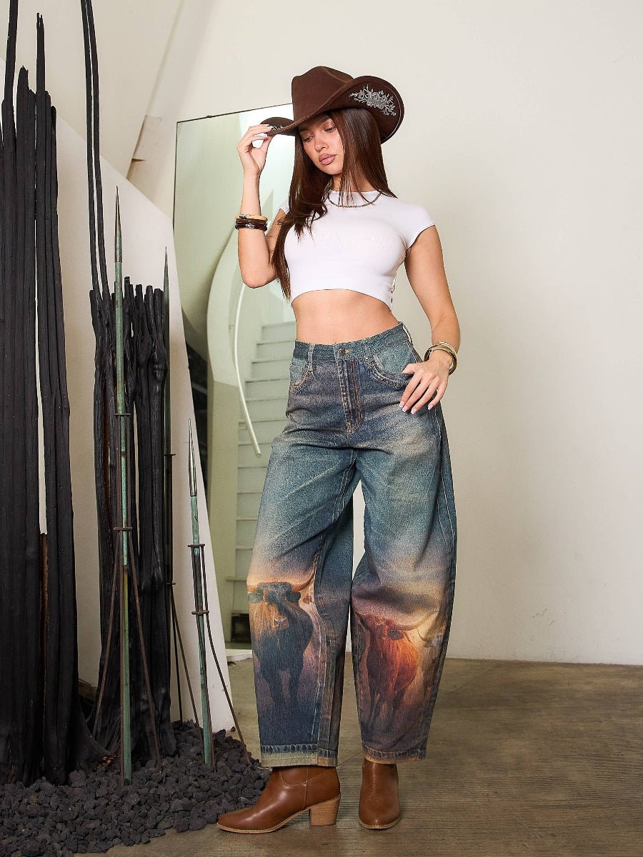 Woman wearing a white crop top, blue tie-dye pants, and brown cowboy hat indoors.