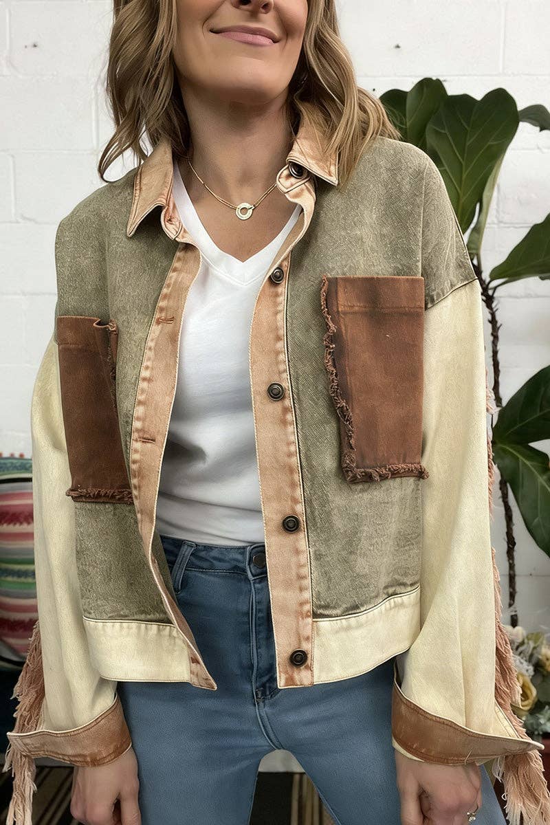 Woman wearing a patchwork jacket with brown and beige colors against a white brick wall.
