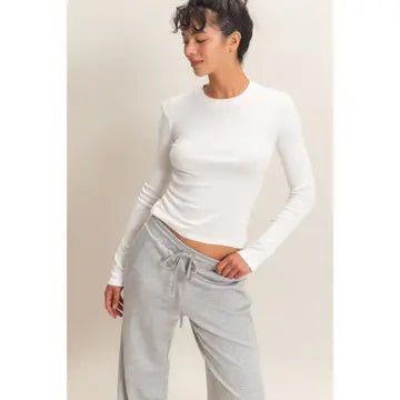 Woman wearing white tight t-shirt and gray pants