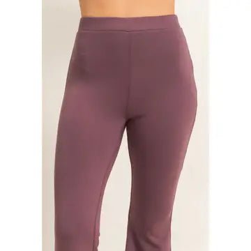 A person wearing high-waisted, form-fitting leggings in a muted mauve or dusty rose color, shown from the waist down against a plain light background.