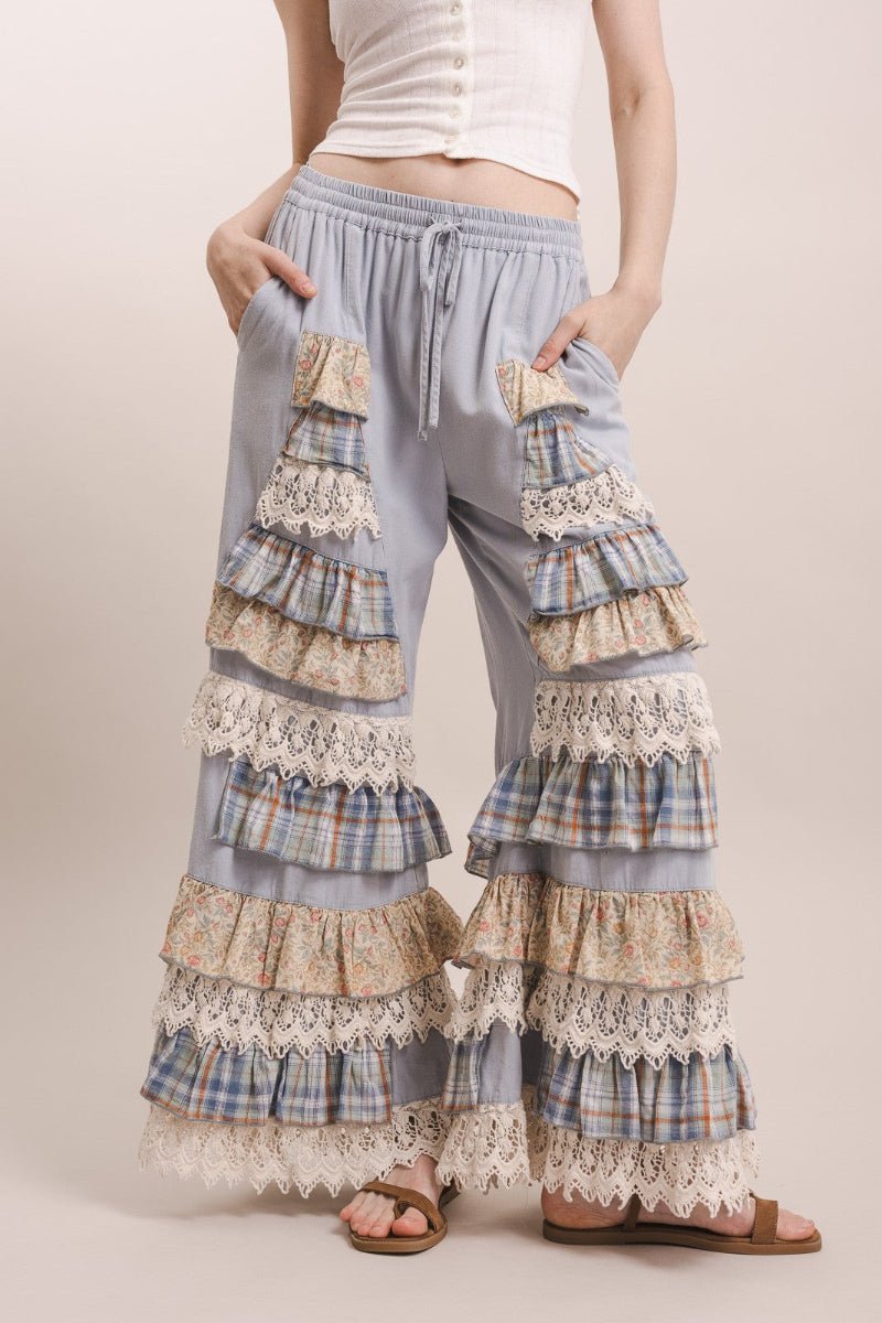 Woman wearing tiered, lace-trimmed pants on a plain background