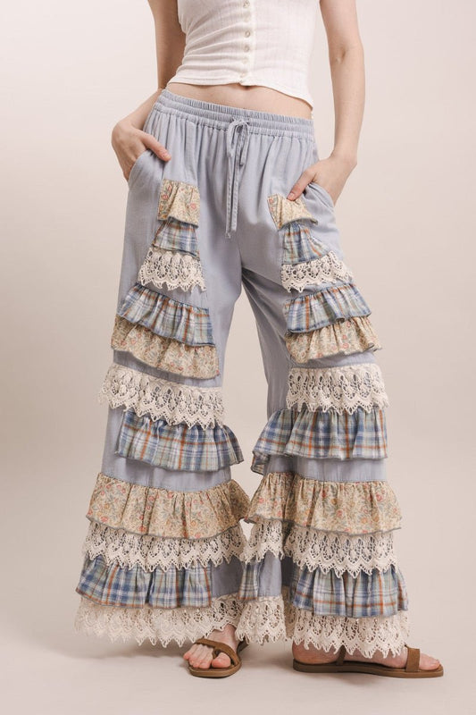 Woman wearing tiered, lace-trimmed pants on a plain background