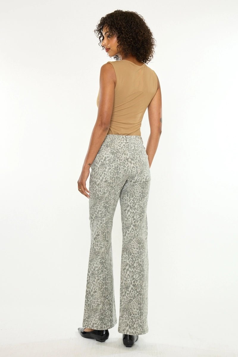 A woman shown from the back wearing light gray and white patterned flared pants with a beige sleeveless top, standing against a plain white studio background.