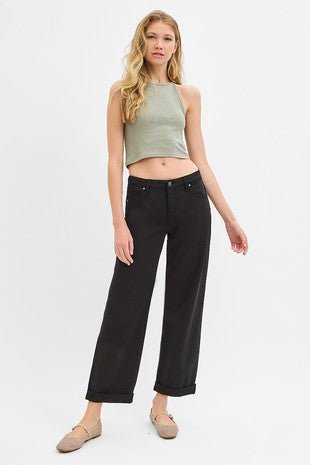 Woman wearing a green top and black pants on a white background