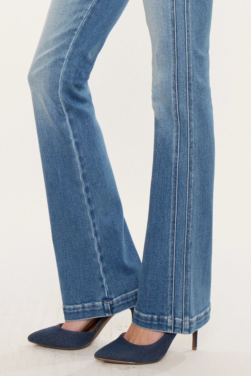 Blue jeans worn with navy high-heeled shoes on a white background