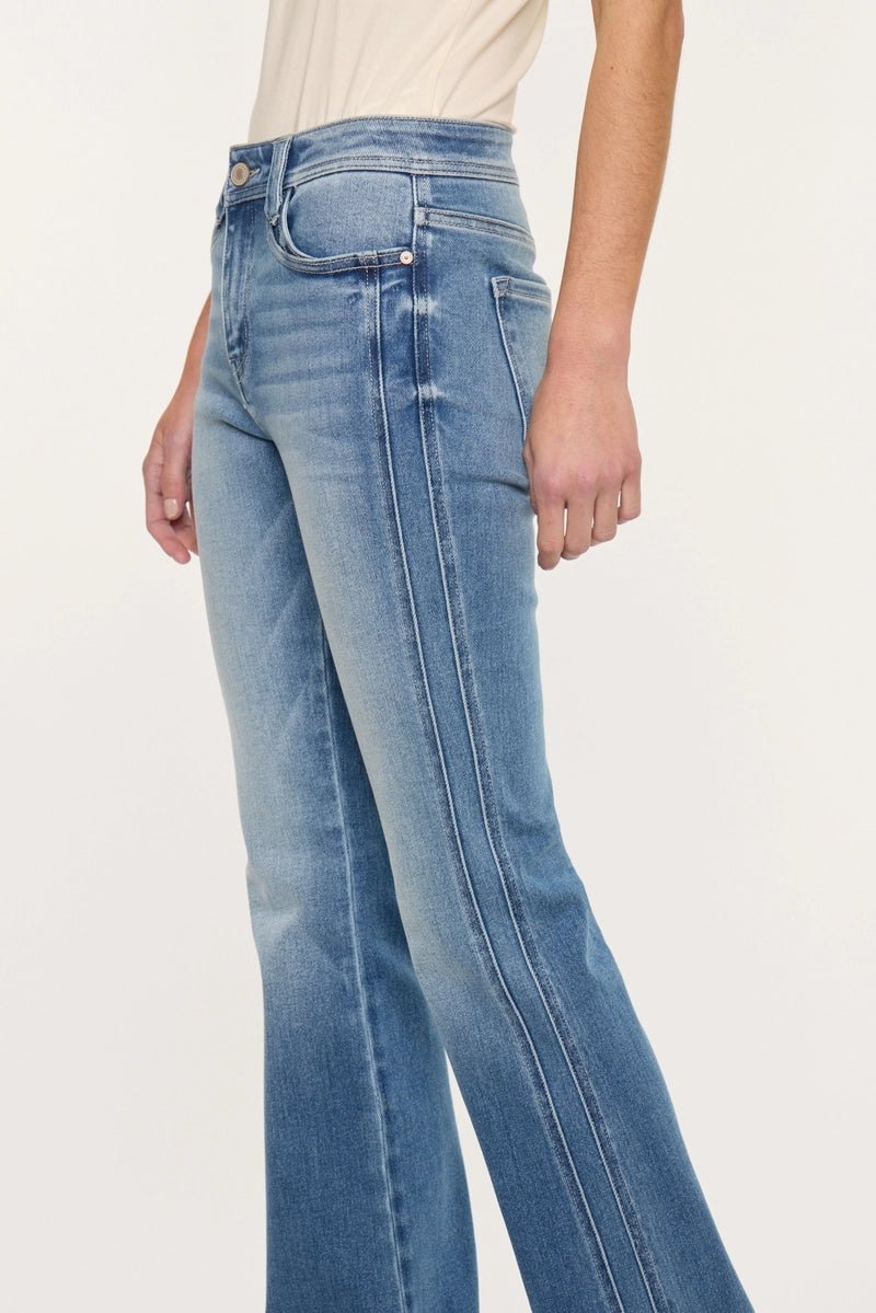 A person wearing light blue high-waisted flare jeans with a faded wash and double-stitch detailing down the front of the legs, shown against a plain light background.