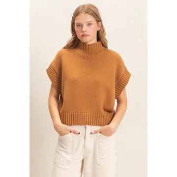 Woman wearing brown sweater and cream pants