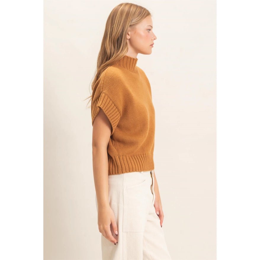 Side View of Woman wearing a brown sweater and cream pans