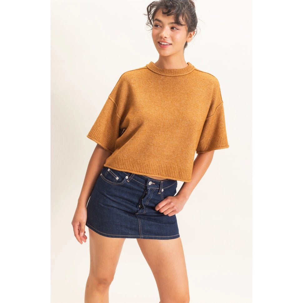 Woman looking to the side wearing a sweater and skirt