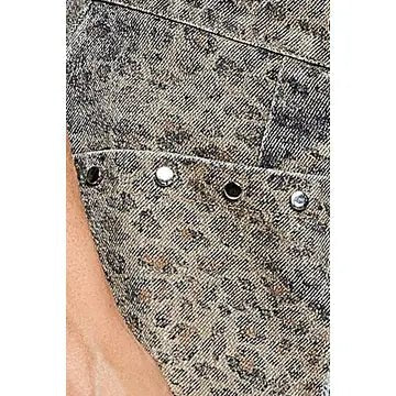 Close-up of a denim garment with a mottled gray and black wash, showing a pocket with metal eyelets and rivets, and part of a person's skin at the edge.