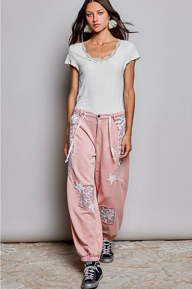 Female wearing white top and pink pants and black shoes