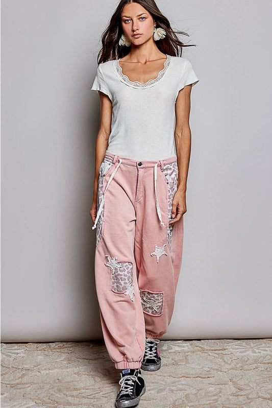 Female wearing white top and pink pants and black shoes