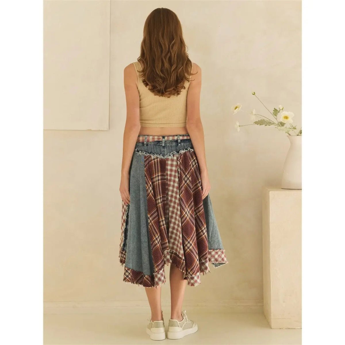 Woman facing wall wearing a denim skirt