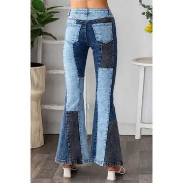 Patchwork flare jeans with a mix of light and dark blue denim panels, shown on a model from the waist down in a home interior setting.