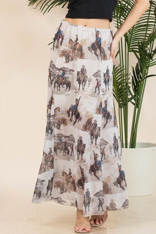 Person wearing a long skirt with horse and rider pattern, standing indoors with plants in the background.