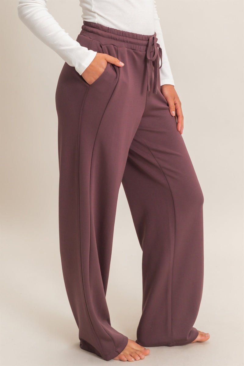 Person wearing brown lounge pants on a plain background