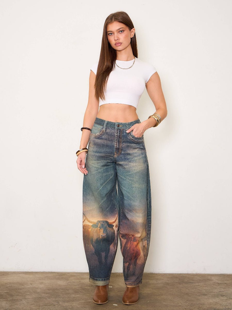 Woman wearing a white crop top and jeans with a nature print, standing against a plain background.